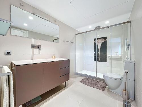 Un baño con inodoro y ducha de cristal. en Casa Nana, en L'Alfas del Pi