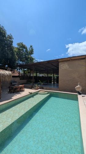 a swimming pool in front of a house at The House of The Rising Tide in Mantaak