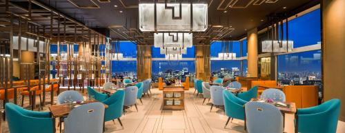 a restaurant with blue chairs and tables and windows at The Prince Gallery Tokyo Kioicho, a Luxury Collection Hotel in Tokyo