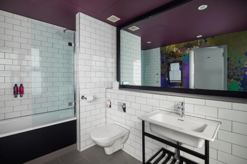 a bathroom with a sink and a toilet and a mirror at Malmaison Newcastle in Newcastle upon Tyne