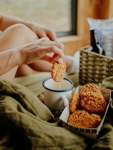 a person holding a piece of food and a cup of coffee at Polaris in Kelsall