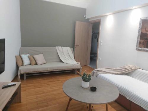 una sala de estar con un sofá y una mesa en Central glow apartment, en Larisa