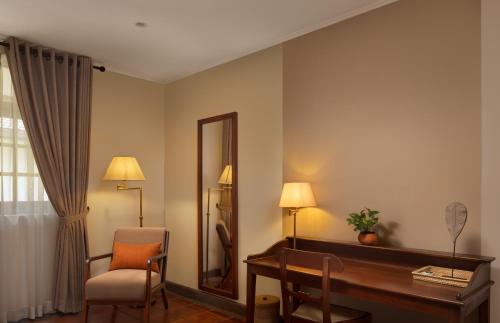 a room with a desk and a mirror and a chair at Tamarind Tree Garden Resort - Katunayake in Negombo