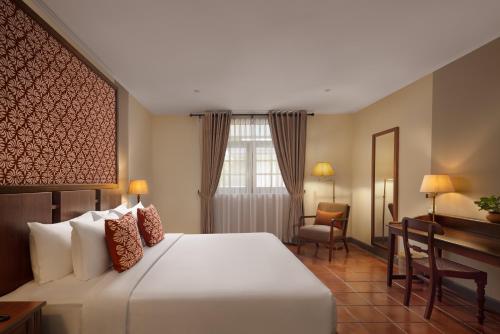 a hotel room with a bed and a desk at Tamarind Tree Garden Resort - Katunayake in Negombo