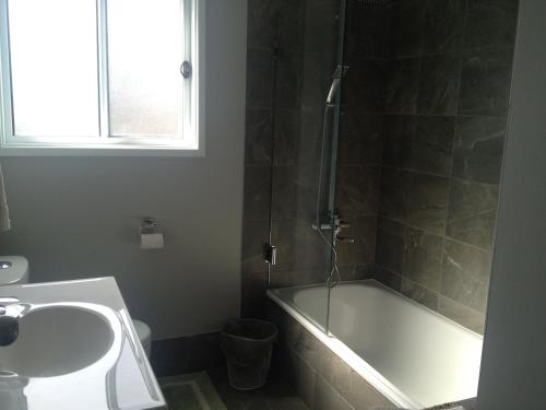 a bathroom with a tub and a sink and a shower at Green Meadow in Nowra