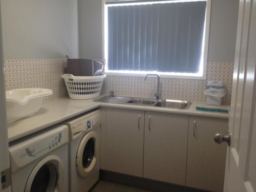 a kitchen with a sink and a washing machine at Green Meadow in Nowra