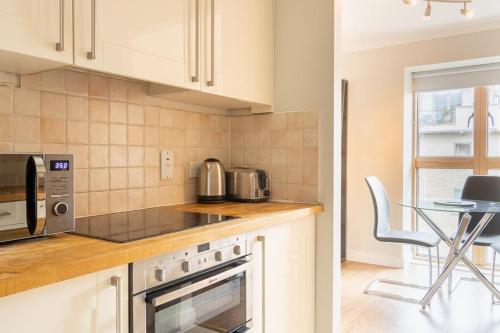 a kitchen with white cabinets and a table with a chair at GuestReady - Suburban retreat in Dublin in Dublin