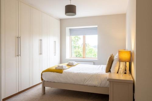 a white bedroom with a bed and a window at GuestReady - Suburban retreat in Dublin in Mount Merrion