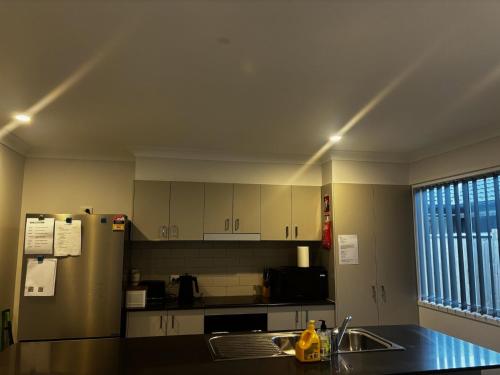 una cucina con lavello e frigorifero di Brassall Haven Retreat a Coalfalls