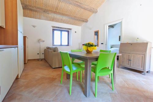 a dining room with a table and green chairs at Calabrialcubo Agriturismo in Nocera Terinese