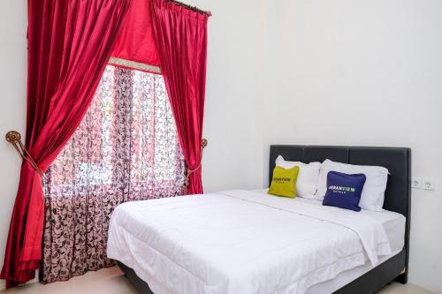 Ένα ή περισσότερα κρεβάτια σε δωμάτιο στο Urbanview Hotel Trisna Tulungagung