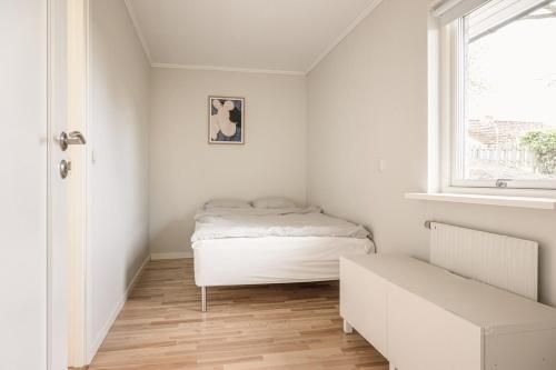 a small bedroom with a bed and a window at Nyrenoverad lägenhet med perfekt läge nära Elmia in Huskvarna