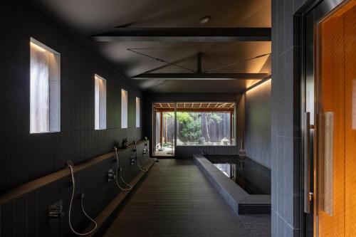a hallway in a bathroom with black walls at Momoyama Onsen Tsukimikan in Kyoto