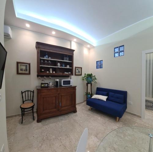 a living room with a blue couch and a tv at Luxury B&B La casa sul mare in Taranto