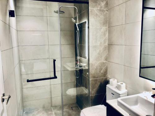 a bathroom with a shower with a toilet and a sink at Axon Residence Pavilion Bukit Bintang SkyView in Kuala Lumpur