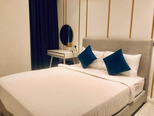 a bedroom with a bed with two blue pillows at Axon Residence Pavilion Bukit Bintang SkyView in Kuala Lumpur