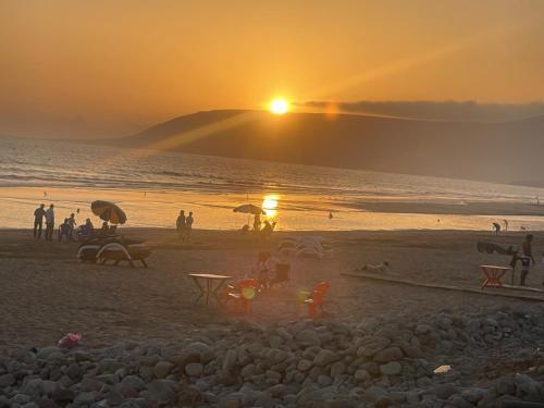 a group of people on a beach at sunset at Villa des Jasmins - Aghroude in Aghroude