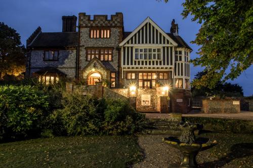 an old stone house with lights on at Dales Country House Hotel in Sheringham