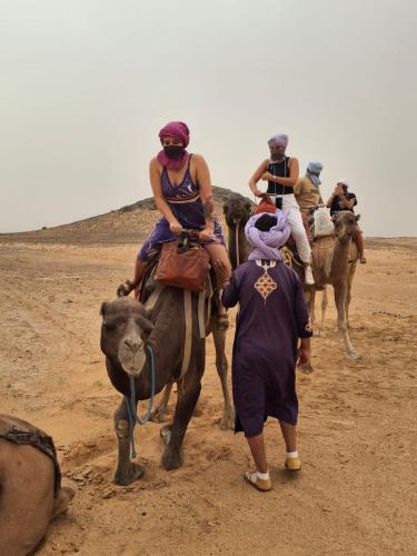 Un grupo de personas montando camellos en el desierto. en Desert Camel Trek, en Merzouga