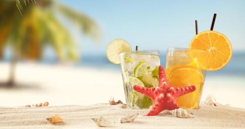 a starfish and two glasses on the beach at The Hideaway Collection at Nonsuch Bay in Gaynors