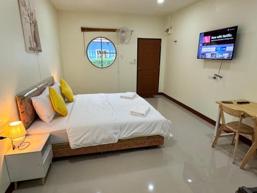 a bedroom with a bed and a tv in it at Muttafa House in Nai Yang Beach