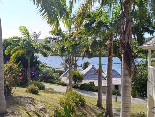 a view of the ocean from a house with palm trees at The Hideaway Collection at Nonsuch Bay in Gaynors