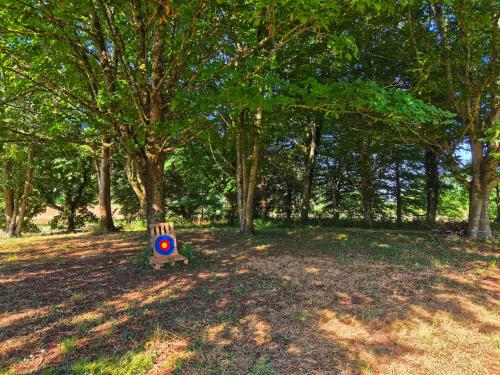 a wooden bench sitting in the middle of a park at Yourte Mongole traditionnelle in Saint-Pé-de-Bigorre