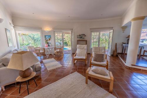 a living room with a couch and chairs and a table at Casa da Aldeia in Bensafrim