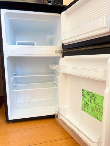 an empty refrigerator with its door open at Mokuga apartment in Tokyo