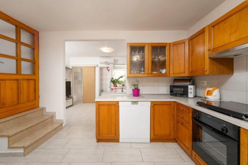 a kitchen with wooden cabinets and white appliances at Casa Nadia in Mošćenička Draga