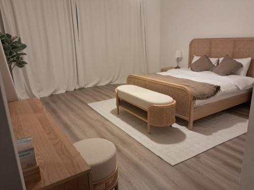 a bedroom with a bed with a bench and a stool at Sara Farm in Abu Dhabi