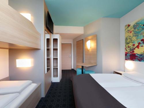 a hotel room with a bed and a desk at B&B Hotel Potsdam in Potsdam