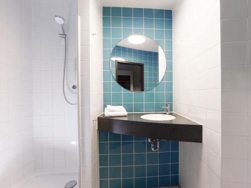 a bathroom with a sink and a mirror at B&B Hotel Potsdam in Potsdam