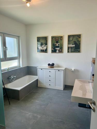a bathroom with a bath tub and a sink at Ferienwohnung Südstraße Dachterrasse in Eschede