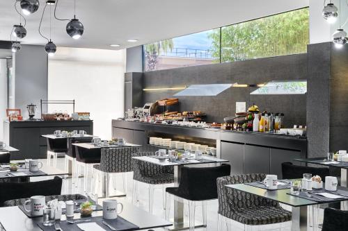 Un restaurante con mesas y sillas y un mostrador. en Ikonik Anglí, en Barcelona