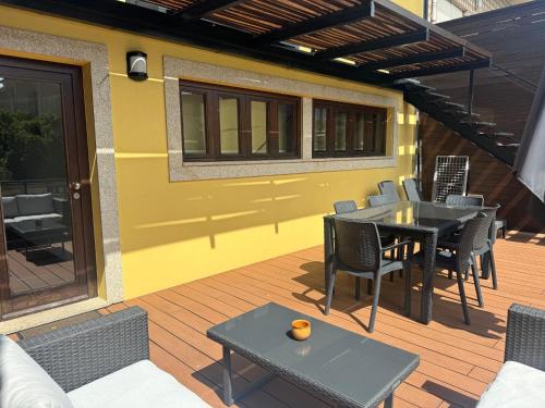 eine Terrasse mit Tisch und Stühlen auf einem Deck in der Unterkunft Misericórdia Garden Homes in Vila do Conde