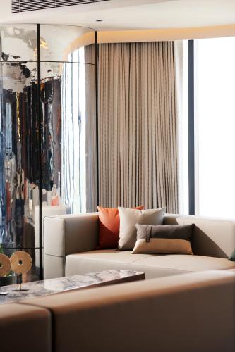 a living room with a couch in front of a window at TRIMULIA Hotel in Sihanoukville