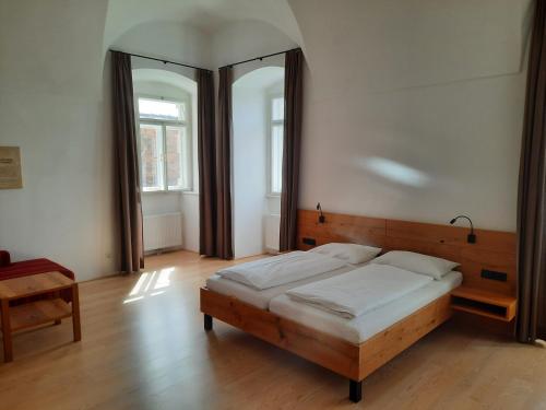 a bedroom with a wooden bed and a large mirror at Gästehaus Benediktinerstift Göttweig - Bed & Breakfast Monastery in Furth