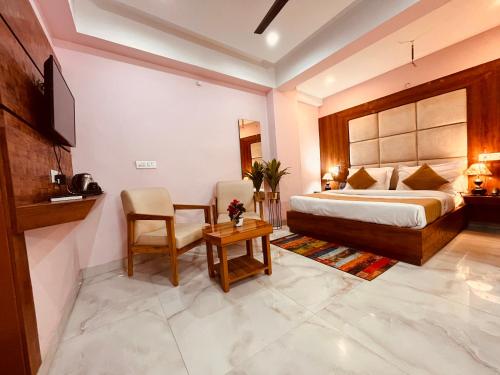 a bedroom with a bed and a table and a chair at Hotel Golden Temple View by la Casa with Swimming Pool in Amritsar