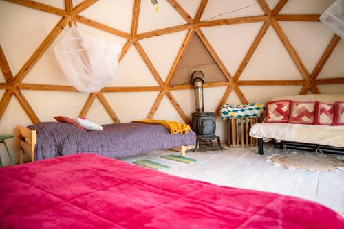 a room with two beds and a stove in a yurt at Centre Harmonia in Rennes-les-Bains