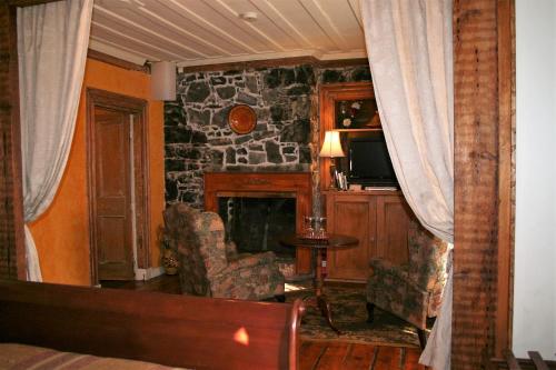 a living room with a fireplace and a stone wall at Gîte À l'Augustine in Quebec City