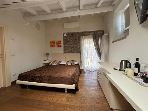 a bedroom with a bed and a kitchen in it at Oreste Suite in Lazise