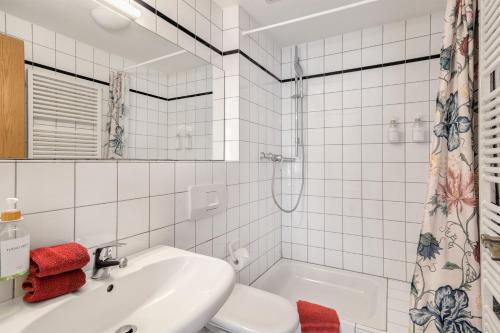 a white bathroom with a sink and a toilet at Ferienwohnungen Benzenberg in Tutzing