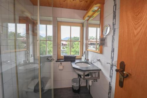Un baño con dos lavabos y una ducha de cristal. en Hafnerlehen, en Berchtesgaden