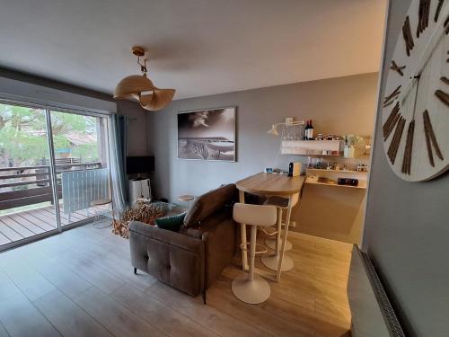 een woonkamer met een tafel en een stoel bij Entre mer et golf in Moliets-et-Maa