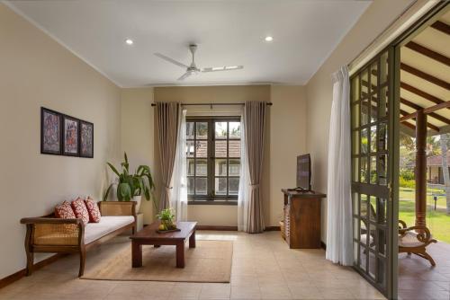 a living room with a couch and a table at Tamarind Tree Garden Resort - Katunayake in Negombo
