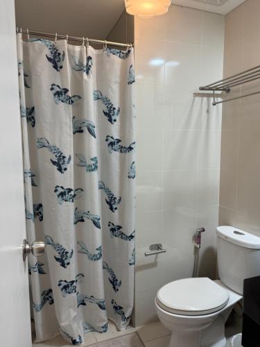 um banheiro com vaso sanitário e cortina de chuveiro em Telly's Studio Across NAIA3 em Manilla