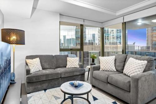 Una sala de estar con dos sofás y una mesa. en Modern 2BR in Brisbane CBD Free Parking and Pool, en Brisbane