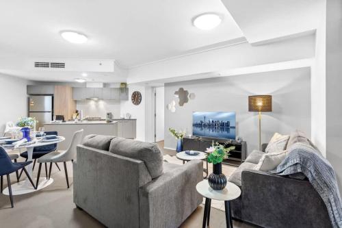 Una sala de estar con dos sofás y una cocina. en Modern 2BR in Brisbane CBD Free Parking and Pool, en Brisbane