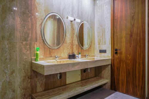 マラケシュにあるVilla Traverta-marrakech luxe et sérénité, 5 suites, 3 salons européens & 1 salon beldi, cuisine américaine équipée, piscine au sel chauffée, hammam traditionnel & services personnalisésの洗面台が2つと鏡が2つあるバスルーム